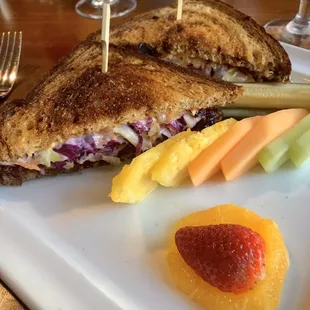 Buffalo Rueben sandwich with fresh fruit.