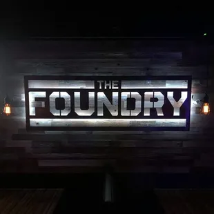 the foundry sign lit up at night