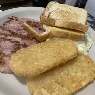 Eggs over easy, Hash Browns, Toast (White), and ham