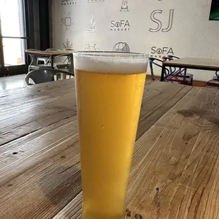 a glass of beer on a wooden table