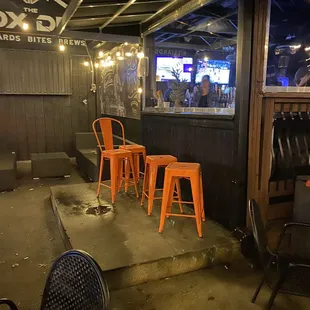 a bar with orange stools