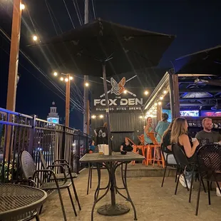 people sitting at tables under umbrellas