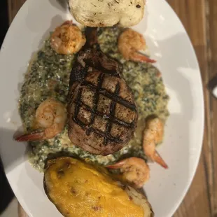 Today special : 14oz pork chop with baked potato , spinach artichoke cream sauce and shrimp. AMAZING !!