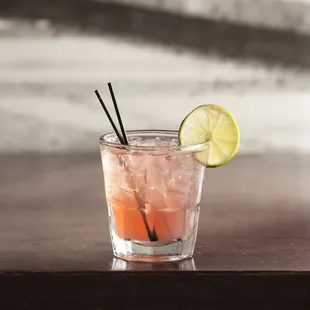 a cocktail with a lime slice on the rim