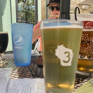 a man sitting at a table with two beers