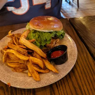 Grilled chicken sandwich with fries.