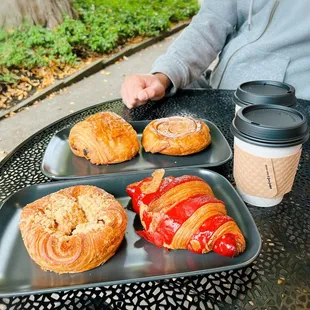 two trays of pastries and a cup of coffee