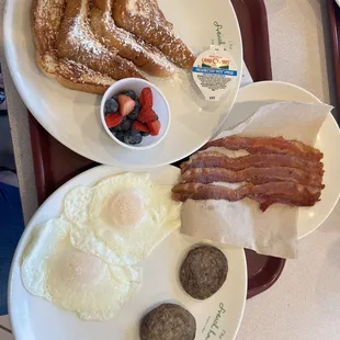 French toast, eggs, sausage patties, and bacon.