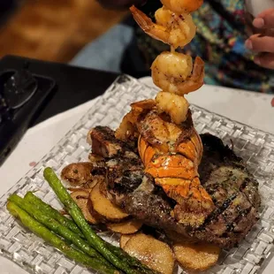 a plate of food with shrimp, potatoes, and asparagus