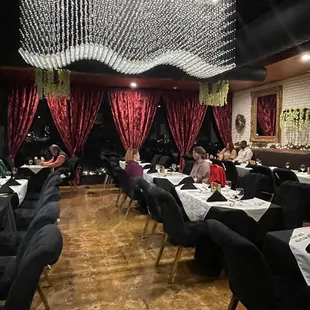 a large dining room with black chairs and white tablecloths