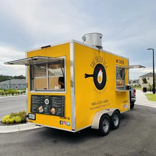 a yellow food truck parked in a parking lot