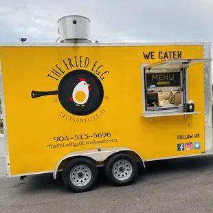 a yellow food truck parked in a parking lot