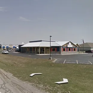 an empty parking lot with a building in the background
