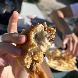 a hand holding a half eaten pastry