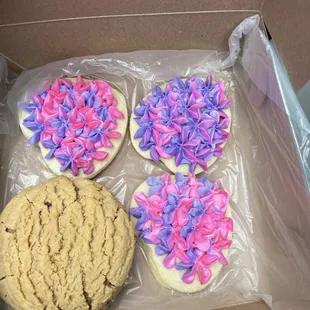 four decorated cookies in a box