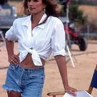 a woman in a white shirt and denim shorts