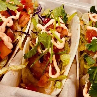 three taco shells with sauce and garnish