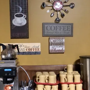 a coffee station with coffee pots and cups