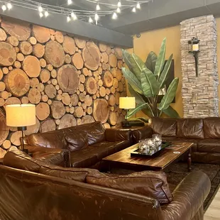 a living room with a stone fireplace and wood walls