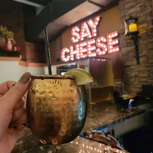 a person holding a glass with a drink in it