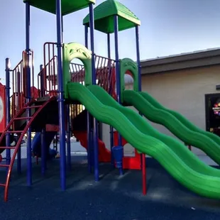 a playground with a green slide