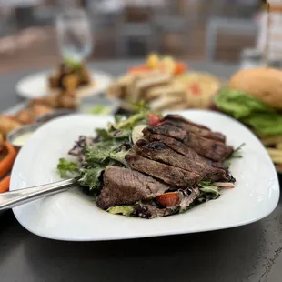 a plate of steak, fries, and salad