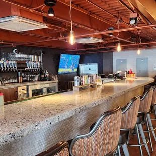 a bar with chairs and a television