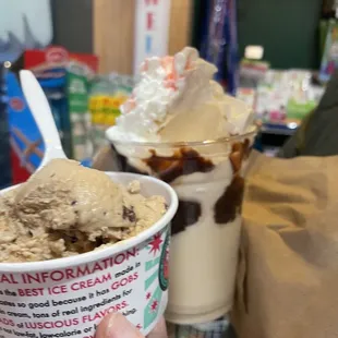 a hand holding a cup of ice cream
