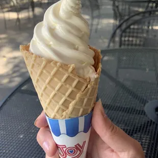 a hand holding a cone of ice cream