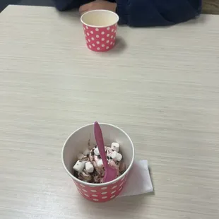 a person sitting at a table with a bowl of ice cream