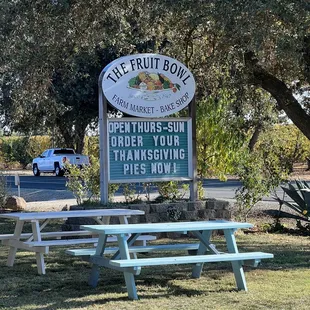 a picnic table in front of a sign