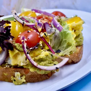 a sandwich with avocado and tomatoes