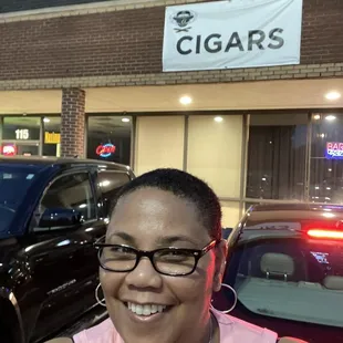 a woman standing in front of a cigar shop
