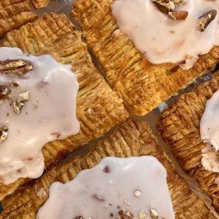 a variety of pastries with icing and nuts