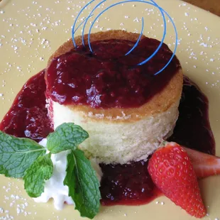 a piece of cake with berries and whipped cream