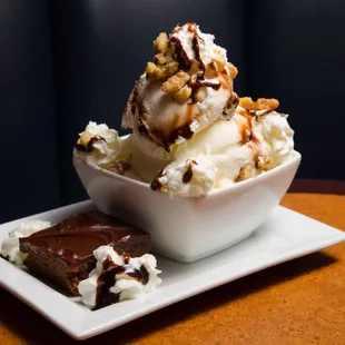 a bowl of ice cream and a piece of brownie