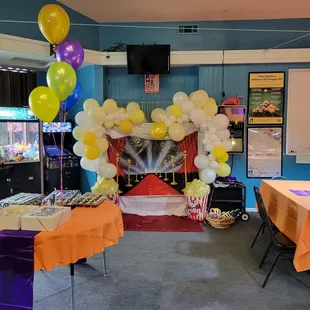 a game room with a fireplace and balloons