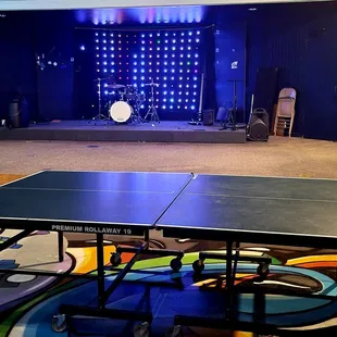 a ping - pong table in the middle of the room