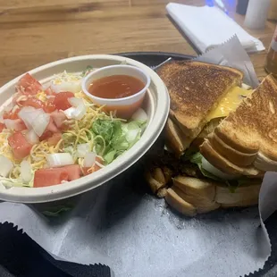 My grill cheese sandwich with burger in the middle and side salad