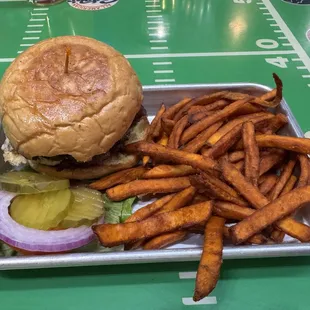 Smash burger with a side of sweet potato fries.