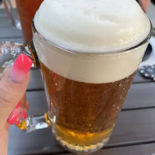 a person holding a glass of beer