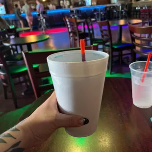 a person holding a cup with a drink in it