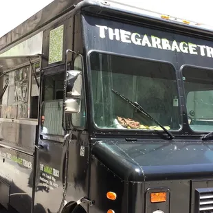 the garbage truck parked on the side of the road