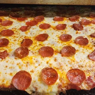 a pepperoni pizza on a grill
