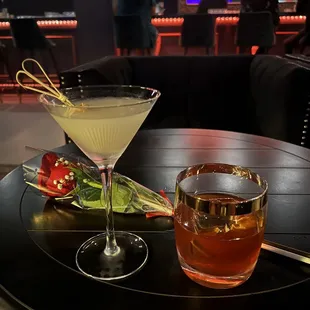 a cocktail and a rose on a table