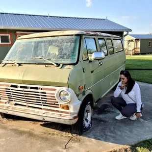 a woman kneeling next to a van
