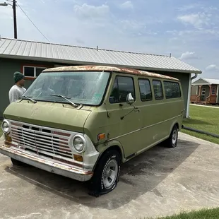 a green van parked in front of a building