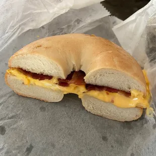 a bagel sandwich with bacon and cheese