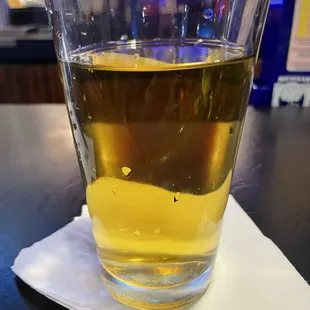 a glass of beer on a napkin