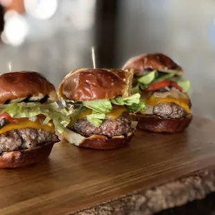 three mini burgers on a cutting board